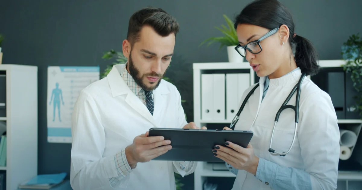 Due medici consultano insieme un tablet in ambulatorio